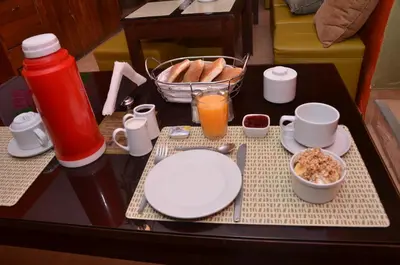 a table topped with plates and bowls of breakfast food at Hostal Mallqui in Cusco