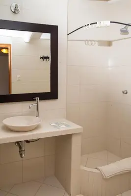 a bathroom with a sink and a mirror and a shower at Amaru Colonial in Cusco
