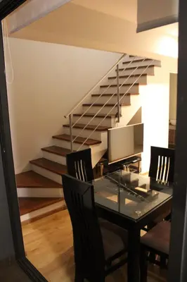 a dining room with a table with chairs and a staircase at Apartamento dúplex exclusivo y céntrico in Lima
