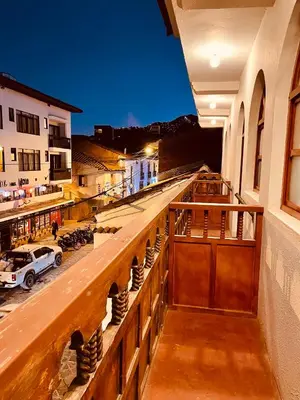 a balcony with a view of a city at night at TATA Hotel Boutique in Cusco