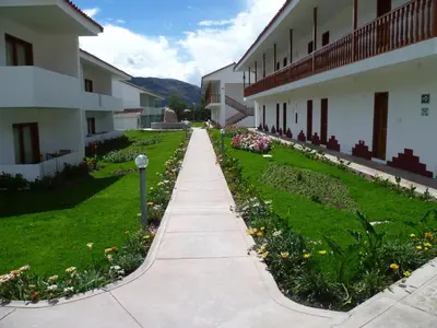 a walkway next to a building with flowers at Hotel Agustos Urubamba in Urubamba