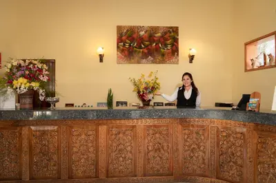 a woman standing behind a bar in a room at Hotel Agustos Urubamba in Urubamba