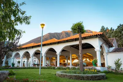 a building with a palm tree in the courtyard at Hotel Agustos Urubamba in Urubamba