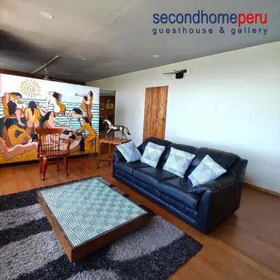 a living room with a black couch and a painting at Second Home Peru in Lima