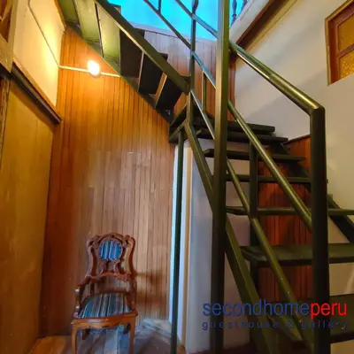 a wooden staircase in a room with a wooden chair at Second Home Peru in Lima