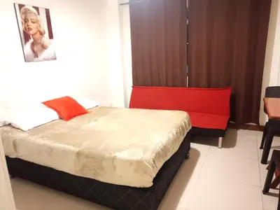 a bedroom with a bed with a red headboard at In the heart of Lima in Lima