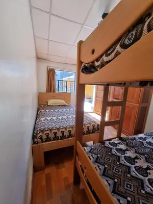 a bedroom with two bunk beds in a house at Chelitos Backpacker in Cusco