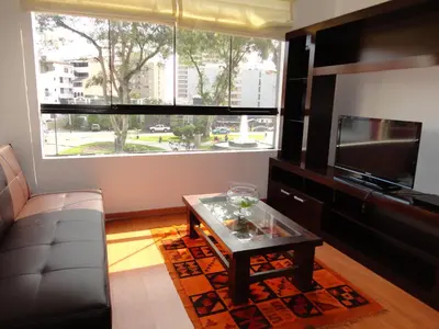 a living room with a couch and a large window at Miraflores Bello Apartamento in Lima