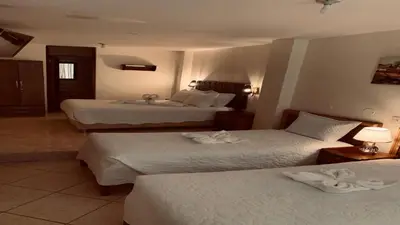 a hotel room with two beds with white sheets at Margarita's House Machupicchu in Machu Picchu