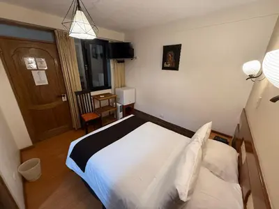 a hotel room with a bed and a door at Awki´s Dream Hotel in Cusco