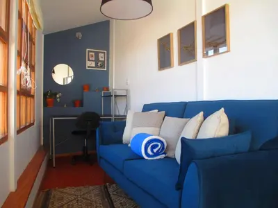 a blue couch with pillows on it in a living room at Quinua Boutique Apartments in Cusco