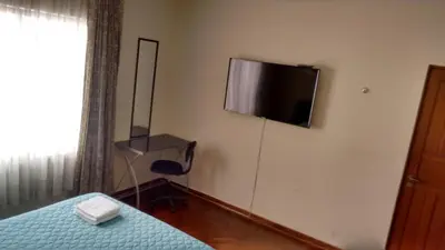 a bedroom with a bed and a flat screen tv on the wall at Cozy and Comfortable Home in MIRAFLORES in Lima