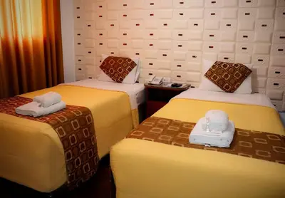 a hotel room with two beds with towels on them at Inkari Apart Hotel in Lima