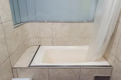 a bath tub in a tiled bathroom with a window at Espacioso confortable apartamento familia in Cusco