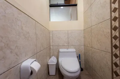 a small bathroom with a toilet and a window at Espacioso confortable apartamento familia in Cusco