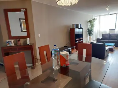 a living room with a glass table and chairs at Apartamento PARDO CCA in Lima