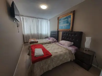 a bedroom with two beds with a red blanket at Apartamento PARDO CCA in Lima