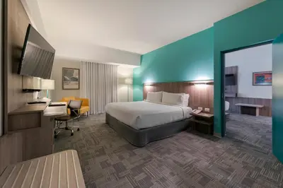 a hotel room with a bed and a desk and a mirror at Holiday Inn - Lima Airport by IHG in Lima