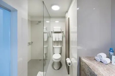 a bathroom with a toilet and a glass shower at Holiday Inn - Lima Airport by IHG in Lima