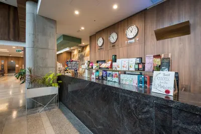 a lobby with a counter with clocks on the wall at Holiday Inn - Lima Airport by IHG in Lima