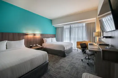 a hotel room with two beds and a desk at Holiday Inn - Lima Airport by IHG in Lima