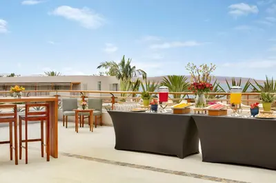 a patio with tables and chairs on a balcony at The Legend Paracas Resort, a Destination by Hyatt Hotel in Paracas