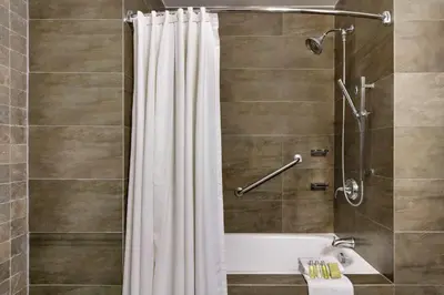 a bathroom with a tub and a shower with a shower curtain at The Legend Paracas Resort, a Destination by Hyatt Hotel in Paracas
