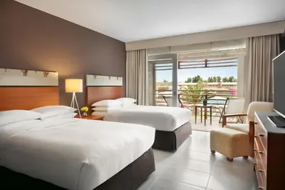 a hotel room with two beds and a balcony at The Legend Paracas Resort, a Destination by Hyatt Hotel in Paracas