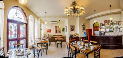 a restaurant with tables and chairs and a bar at Hotel Carmel in Lima