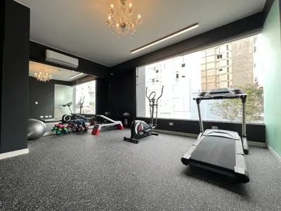 a gym with several exercise equipment and a large window at Habitat Hotel in Lima