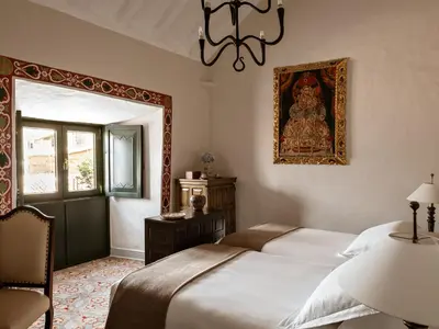 a bedroom with a bed and a picture on the wall at Monasterio, A Belmond Hotel, Cusco in Cusco
