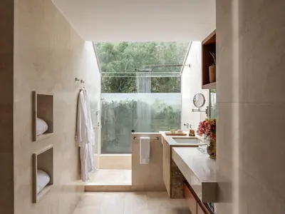 a bathroom with a sink and a shower with a window at Rio Sagrado, A Belmond Hotel, Sacred Valley in Urubamba