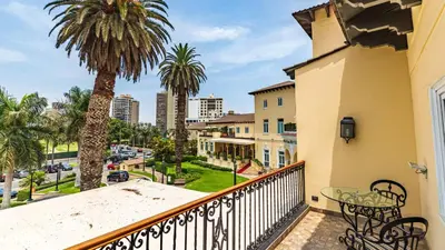 a balcony with a table and a palm tree at Country Club Lima Hotel – The Leading Hotels of the World in Lima
