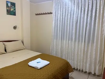 a bedroom with a bed and a window with curtains at Sandel in Barranca