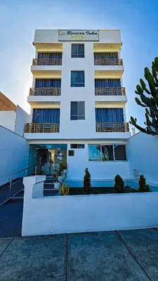 a tall white building with a staircase in front of it at Hotel Riviera Inka Paracas in Paracas