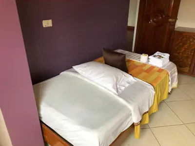 two beds in a room next to each other at Prince Hospedaje in Ayacucho