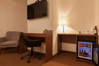 a room with a desk and a chair and a television at Inti Punku Machupicchu Hotel & Suites in Machu Picchu
