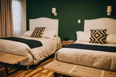 two beds in a room with a green wall at Anden Inca Hotel in Cusco