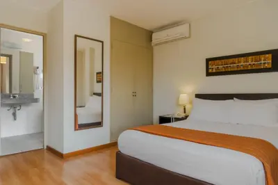 a bedroom with a large bed and a bathroom at Girasoles Hotel in Lima