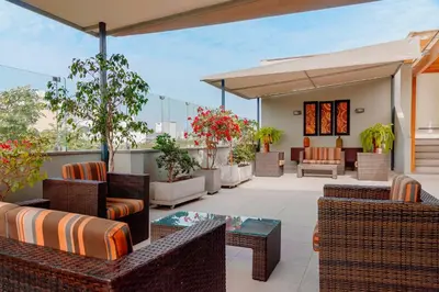 an outdoor patio with wicker chairs and tables at Girasoles Hotel in Lima