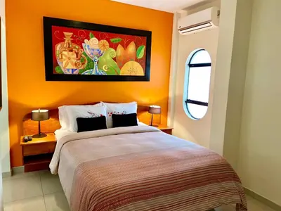 a bedroom with a large bed with an orange wall at Peru Star Apart-Hotel in Lima
