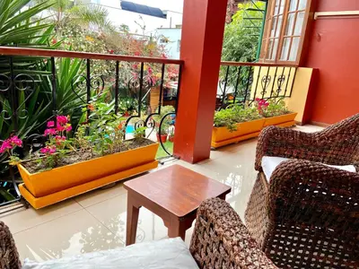 a balcony with two chairs and a table and flowers at Peru Star Apart-Hotel in Lima
