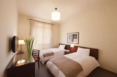 a hotel room with two beds and a television at LP Los Portales Hotel Tarma in Tarma