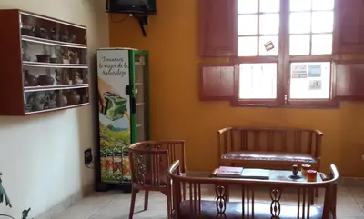 a room with a table and two chairs and a refrigerator at Hotel La Casona in Pisco