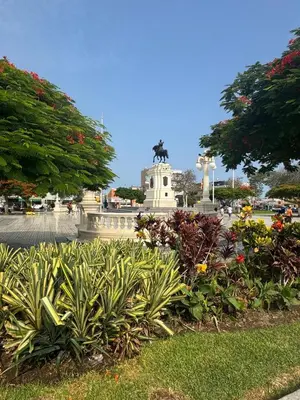 a park with flowers and a statue in the background at Hotel La Casona in Pisco
