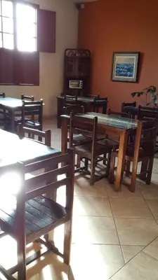 a dining room with wooden tables and wooden benches at Hotel La Casona in Pisco