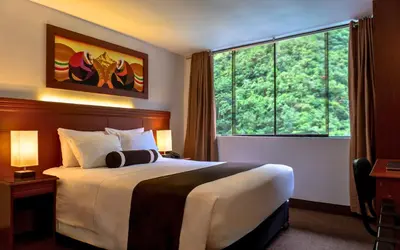 a hotel room with a bed and a large window at Hotel Ferré Boulevard in Machu Picchu