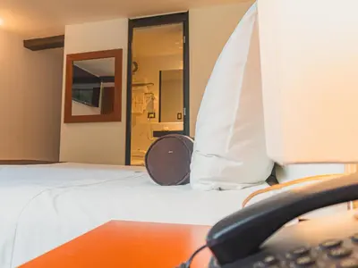 a room with a bed with a phone on it at Hotel Ferré Boulevard in Machu Picchu