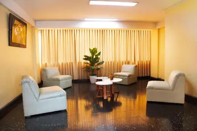 a waiting room with chairs and a table and a plant at Hotel Olaya in Lima