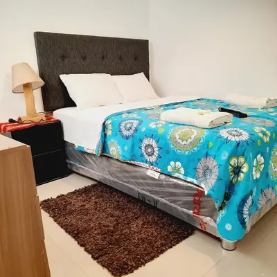 a bedroom with a bed with a blue comforter at Hostal Brisa Marina in Paracas